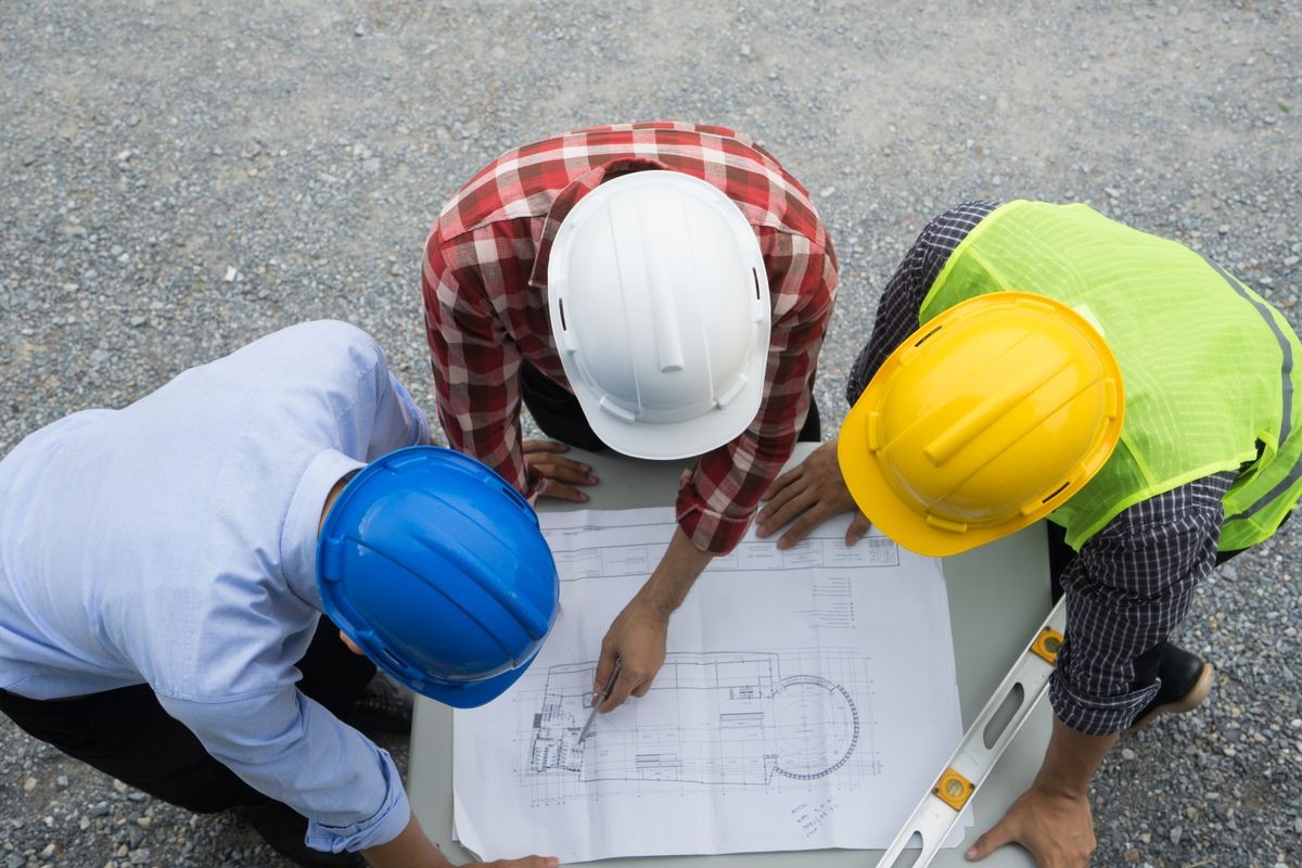 Group of civil engineer or architect, safety helmet and green reflective vest, working on construction site, blue print discussing, Real estate , construction industry and business concept.